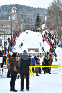 a crowd watches skiiers come down a ski hill