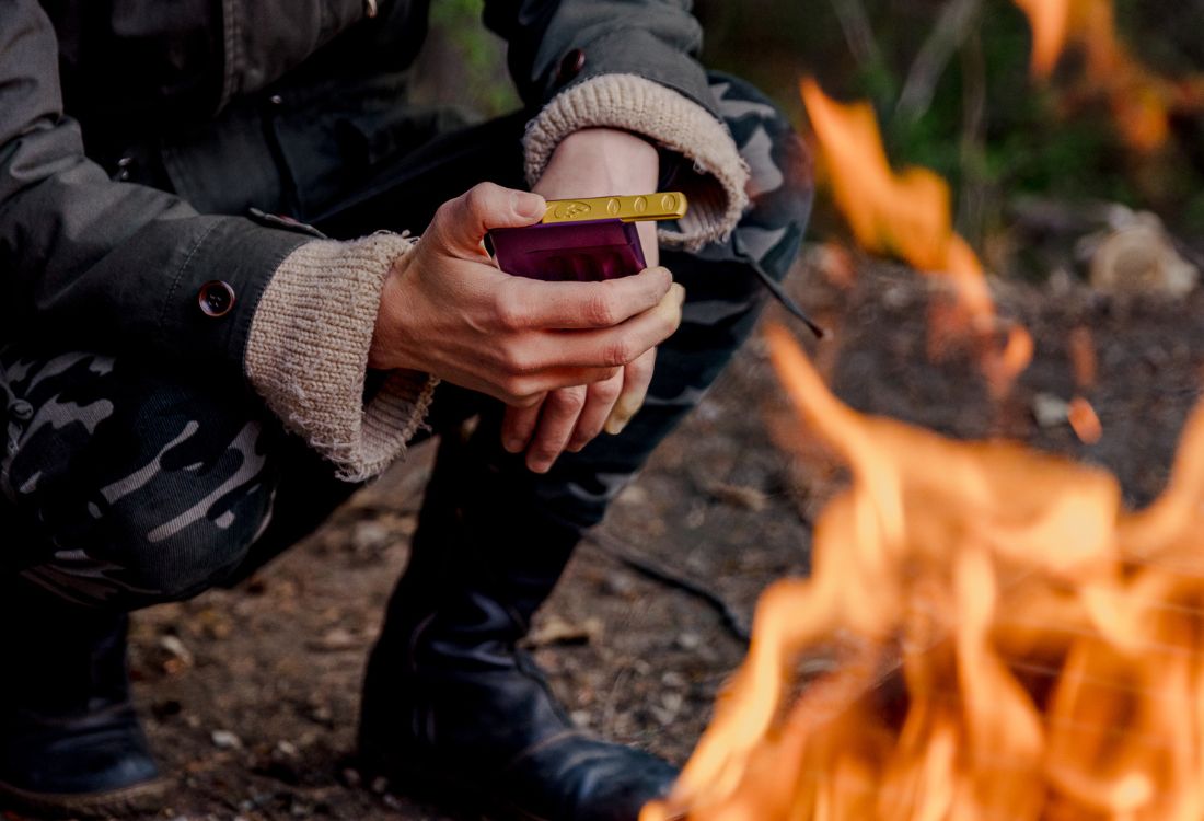 a person holds a joint case next to a fire