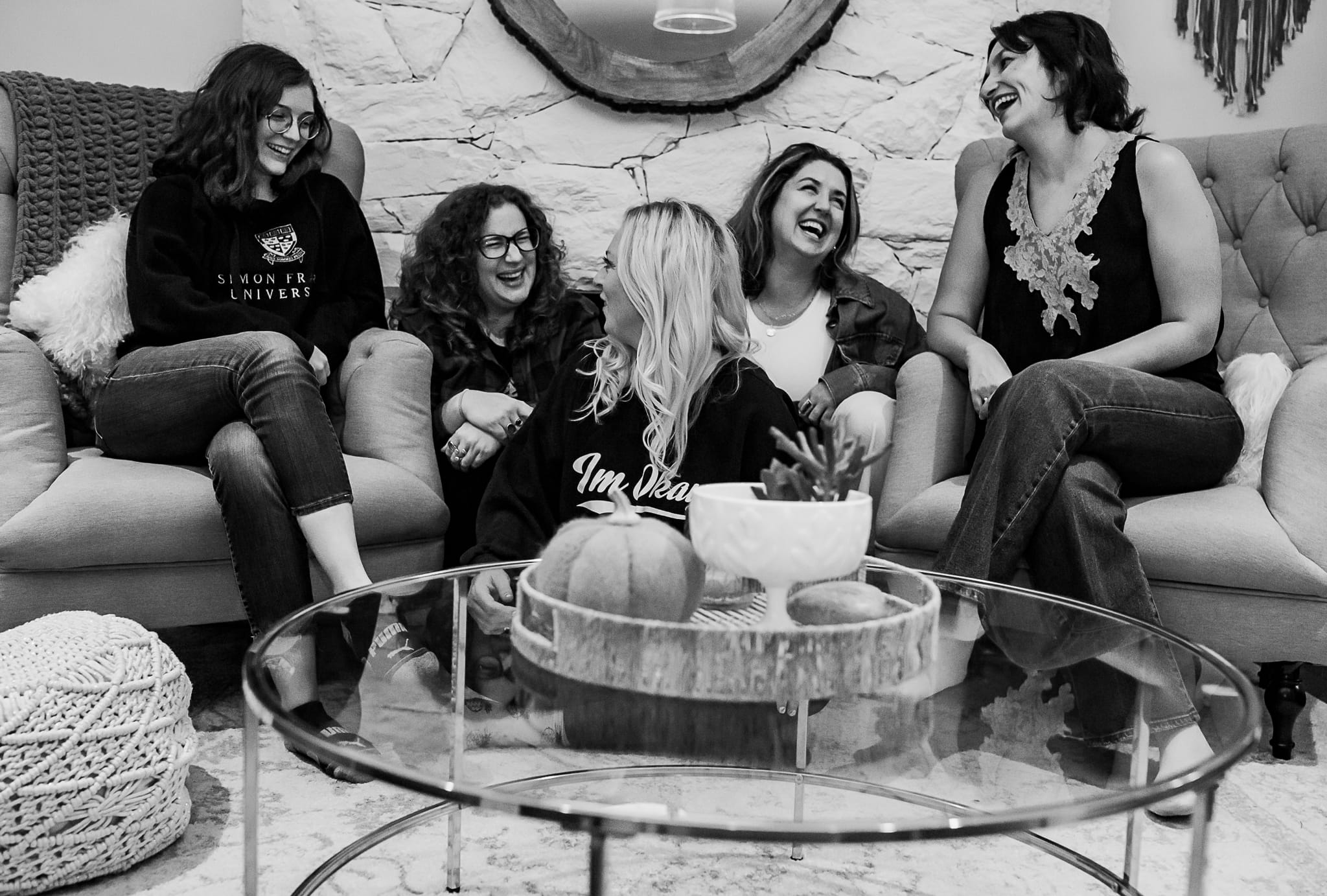 five caucasian women laugh together in a sitting room